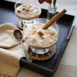 mexican rice pudding, known as arroz con leche, in short coupe glasses and garnished with cinnamon on a black serving tray