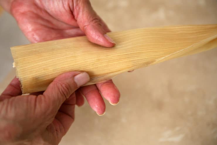 how to assemble tamales hands folding a tamal
