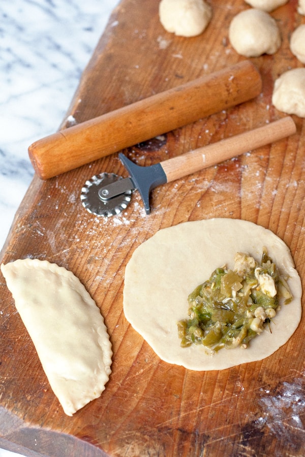 forming empanadas filled with roasted green Chile and cheese 