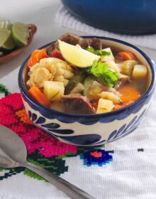 bowl of mexican vegetable beef soup in a white and blue painted ceramic bowl
