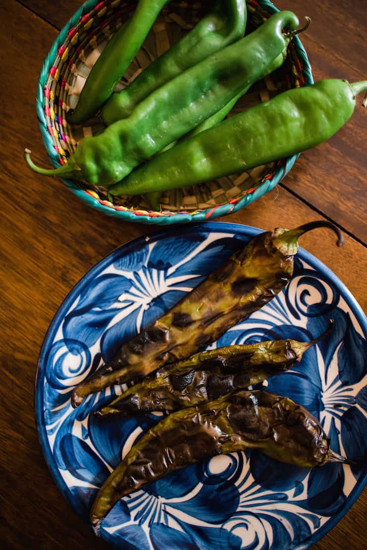 roasted long green Chile on a plate and fresh green Chile in a basket