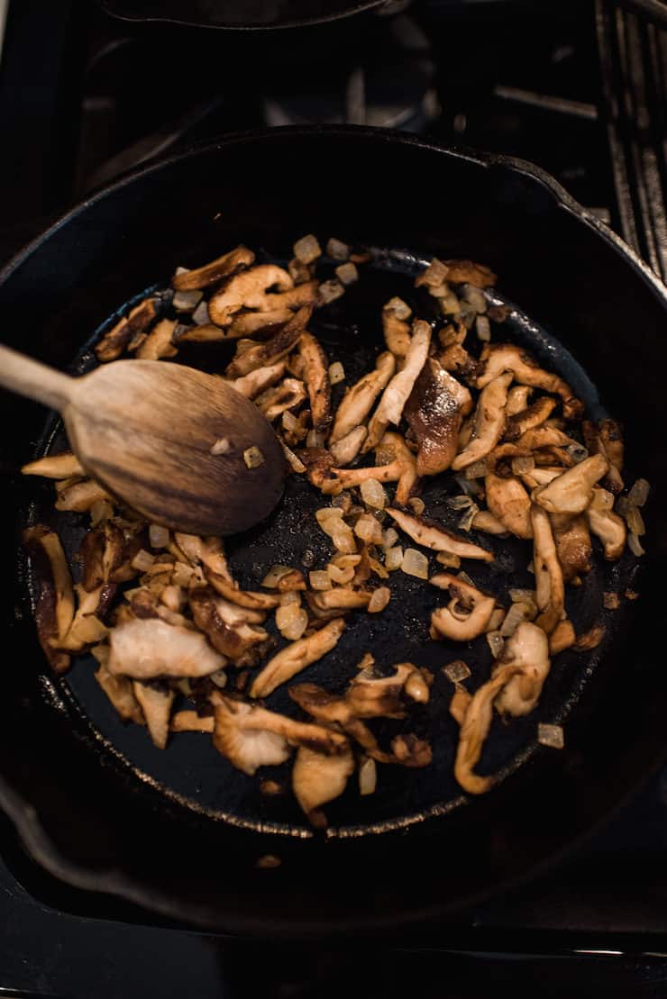 mushrooms and onions sautéing in an iron skillet