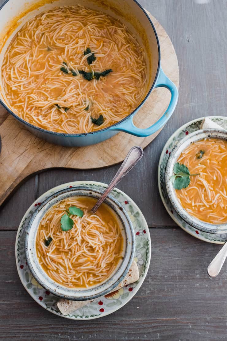 sopa de fideo in a pot and two bowls