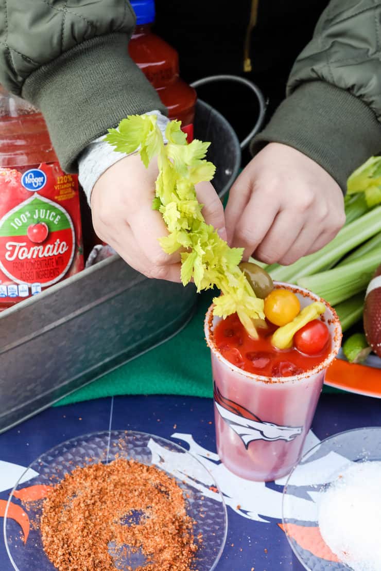 hands garnishing a Bloody Mary 