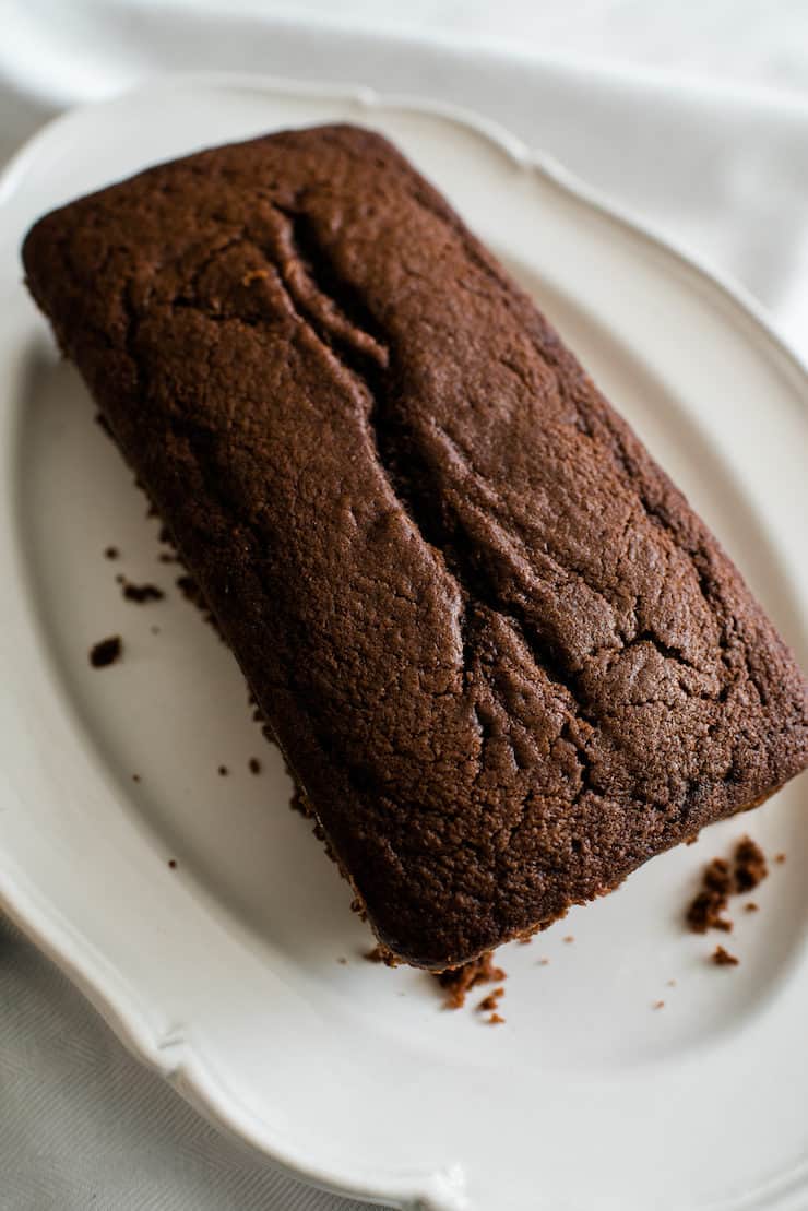 unglazed chocolate applesauce bread on a white plate on a white cloth