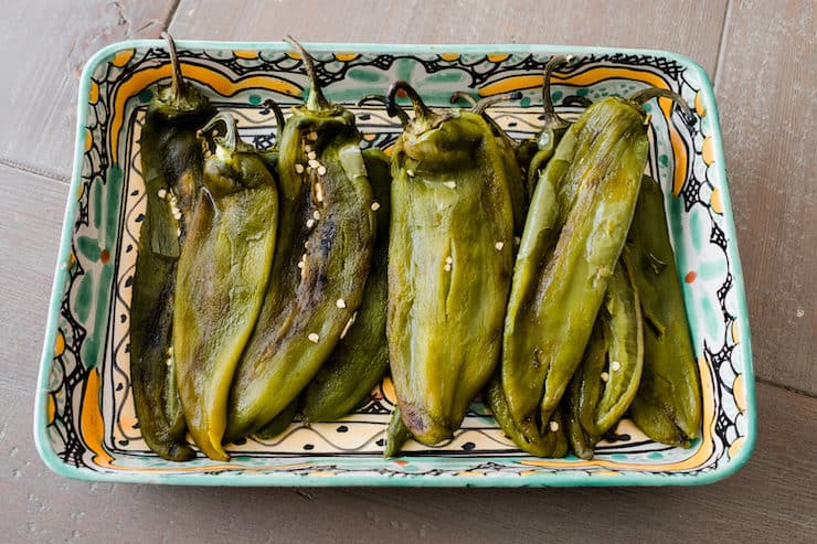 roasted long green chili peppers in a casserole dish to make 