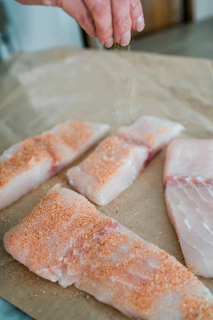 Applying dry spice rub on fish fillet