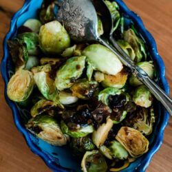 Maple Syrup Chipotle Roasted Brussels Sprouts side dish served in a beautiful blue plate
