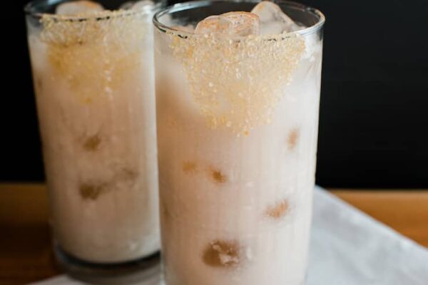 Two glasses filled with ice and horchata with tequila