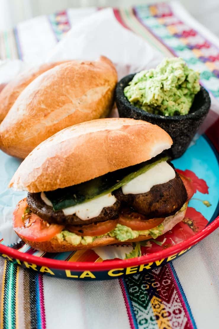 vegetarian torta made with bolillos and roasted poblanos and portobello mushrooms with guacamole and cheese