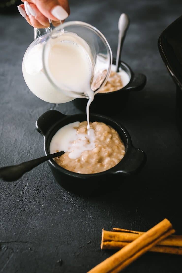pouring milk into a bowl of Slow Cooker Oatmeal