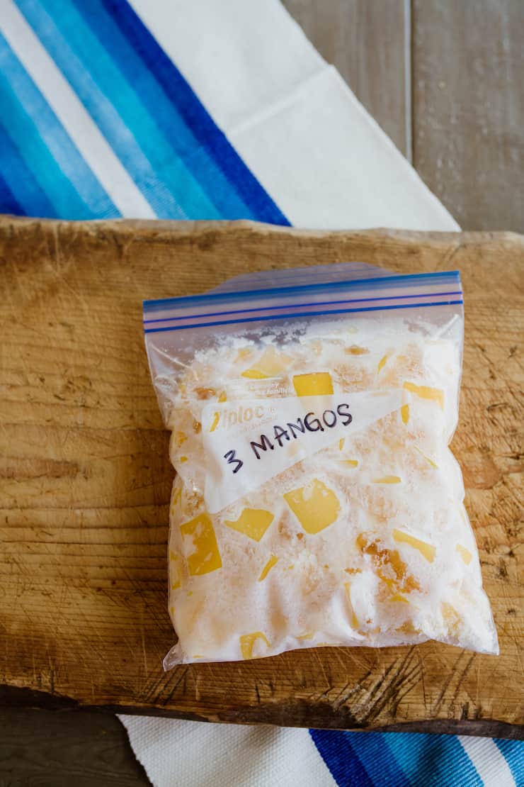 ziplock bag filled with frozen mango chunks to make Mangonada Margaritas