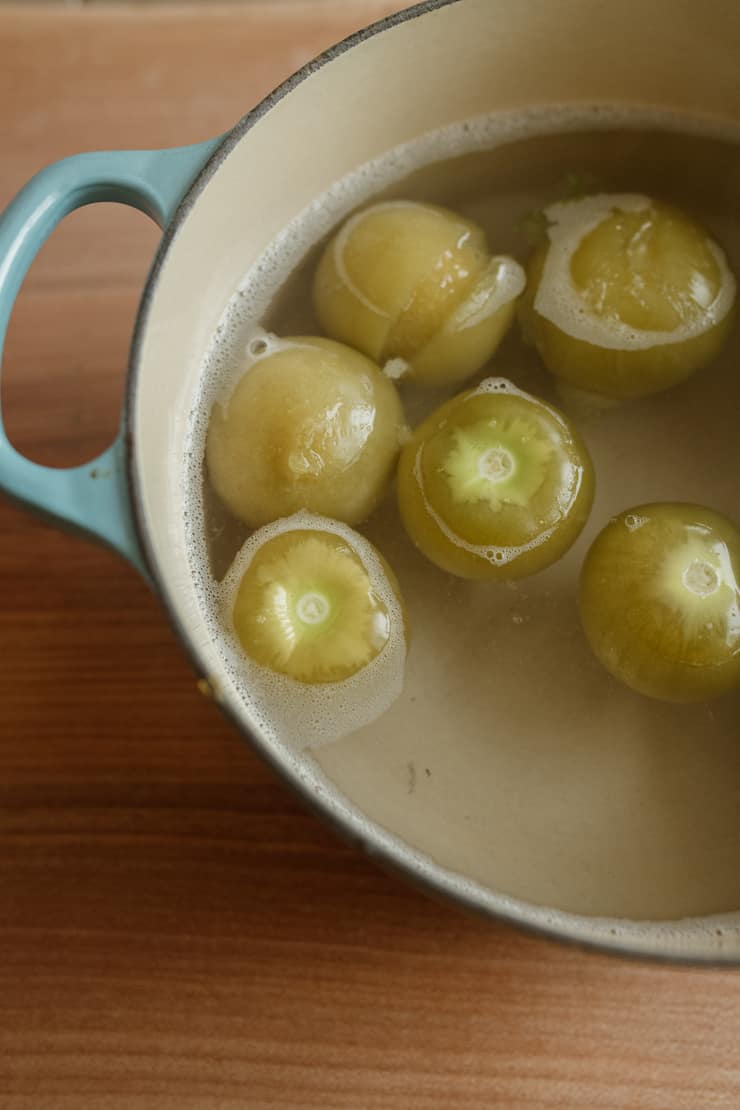 Cooked tomatillos in a stock pot in water boiled in a pan