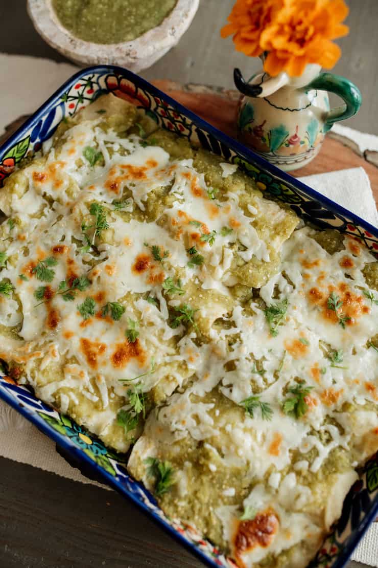 baked Shrimp Enchiladas with Salsa Verde in a talavera Mexican baking dish on a table