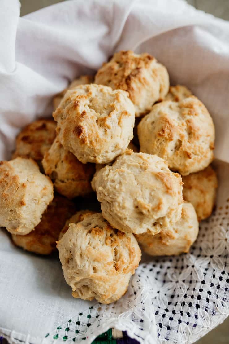 a basket filled with drop biscuits on a white lace cloth