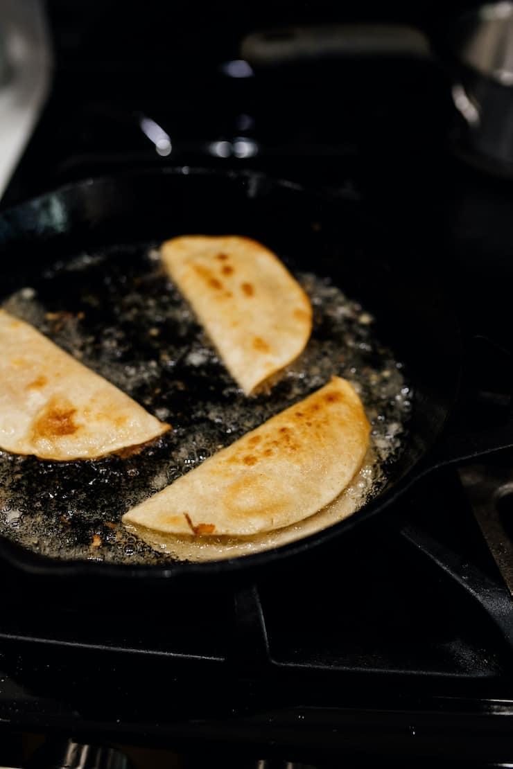 vegetarian tacos being fried in a cast iron pan