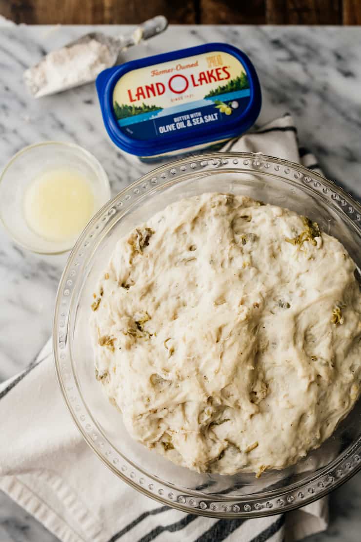 bowl of easy no knead bread recipe in dough form in a bowl with land o lakes butter container