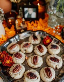 pecan shortbread cookies with marigolds in the background on a day of the dead altar
