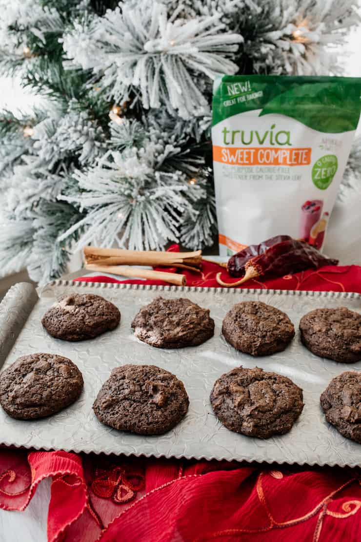 mexican hot chocolate cookies on a silver tray with a christmas tree and a bag of truvia in the background
