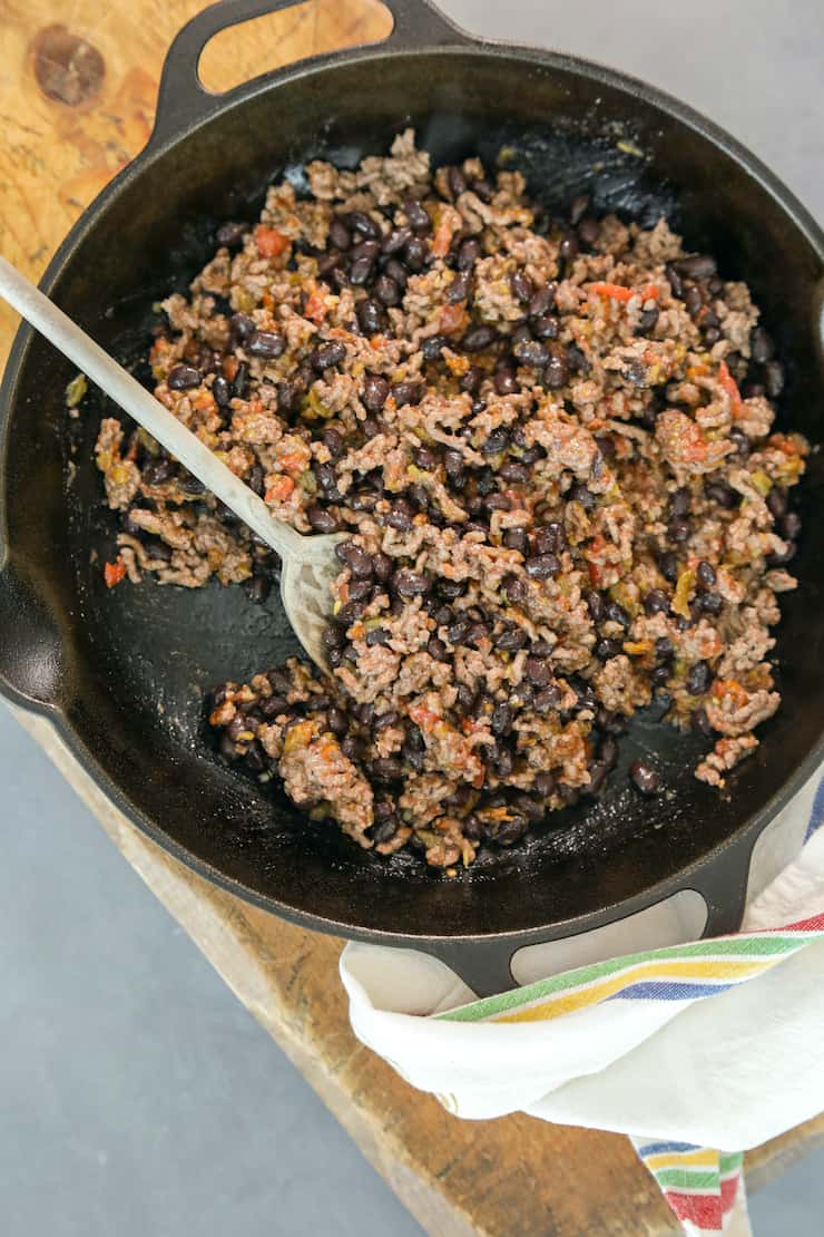 overhead shot of ground beef with beans and salsa as classic nacho topping