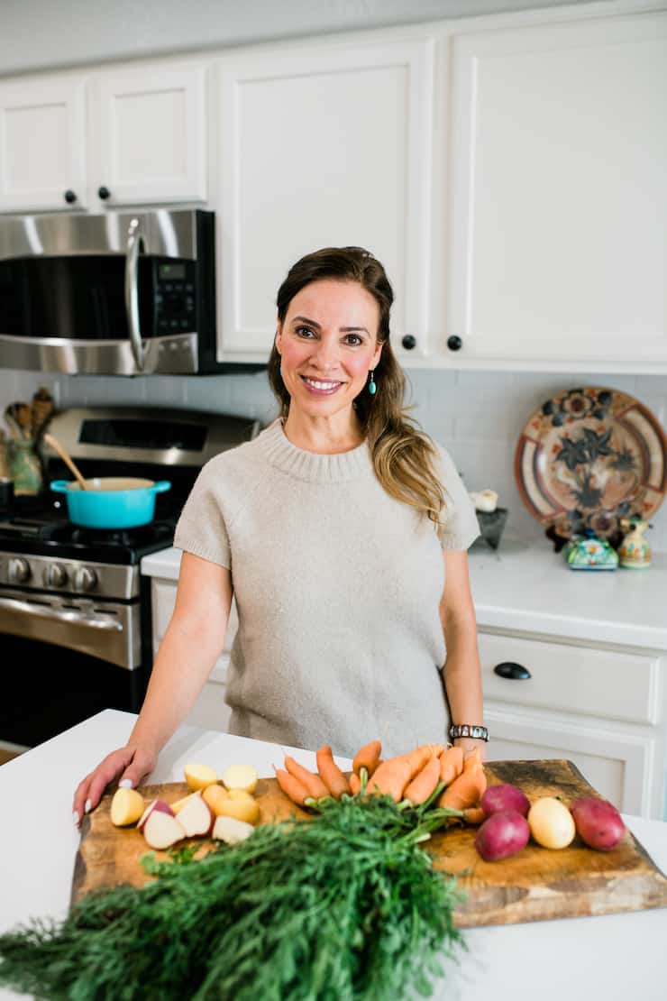 Yvette Marquez latina author in kitchen with a cutting board full of veggies