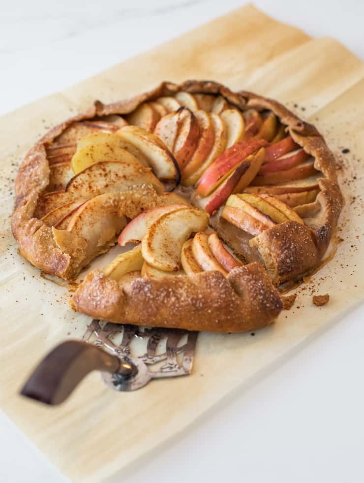 apple galette on a wooden cutting board with a silver pie server