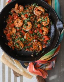 black cast iron sauté pan filled with cooked ranchero style shrimp