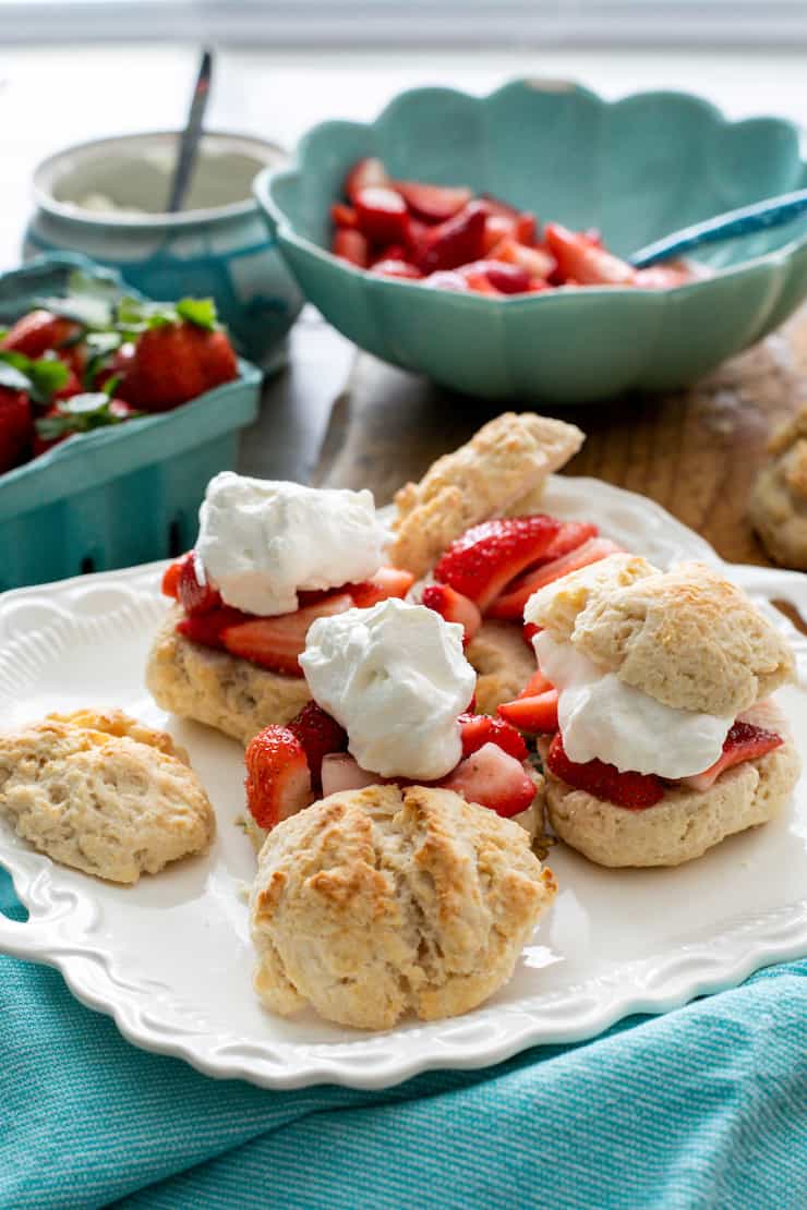 homemade biscuits sliced and topped with strawberries and whipped cream for homemade strawberry shortcakes