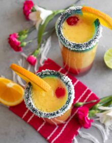 overhead shot of frozen sunrise margaritas in tall collins glasses with salted rims
