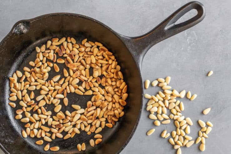 toasted pinon pine nuts in a cast iron skillet