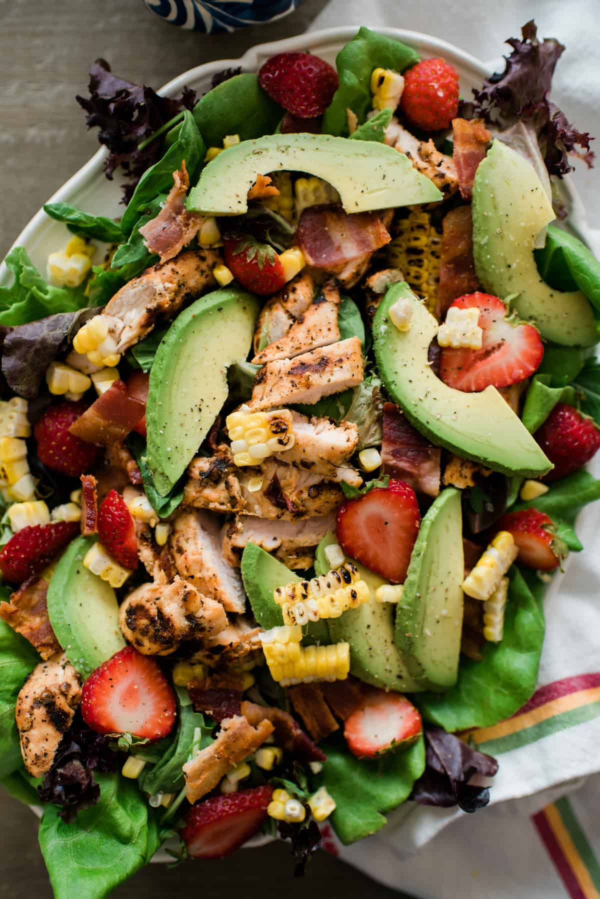overhead shot of Summer Chipotle Chicken Salad styled like a cobb with slices of chicken and avocado on top