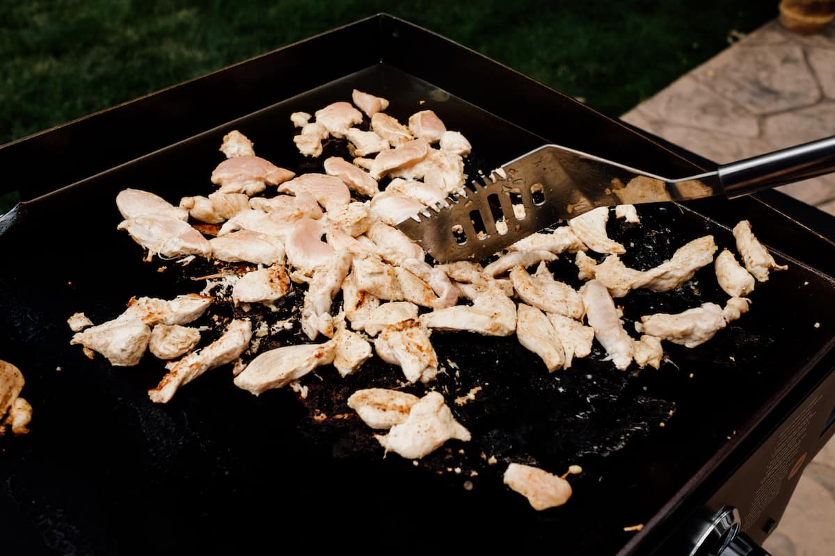 cooking chicken on a Blackstone griddle outside for chicken fajitas