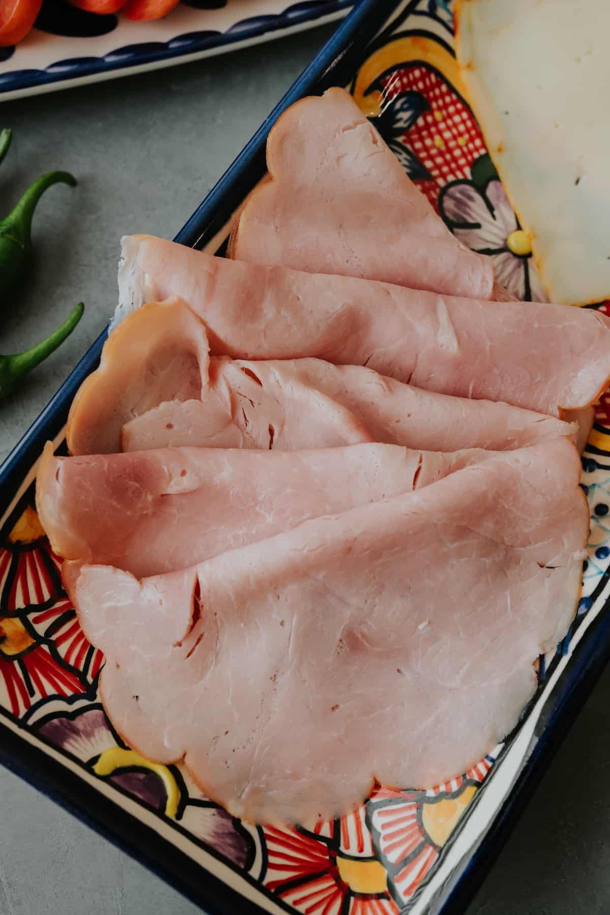 thin sliced deli ham on a painted plate