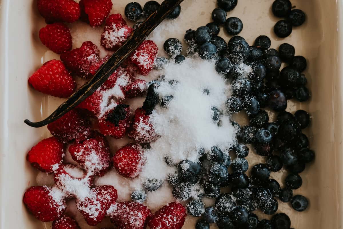 sprinkled sugar over berries plus a vanilla bean pod