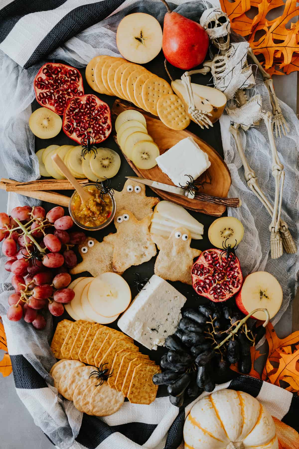 Halloween Cheese Board filled with fresh fall fruits, crackers, and cheese