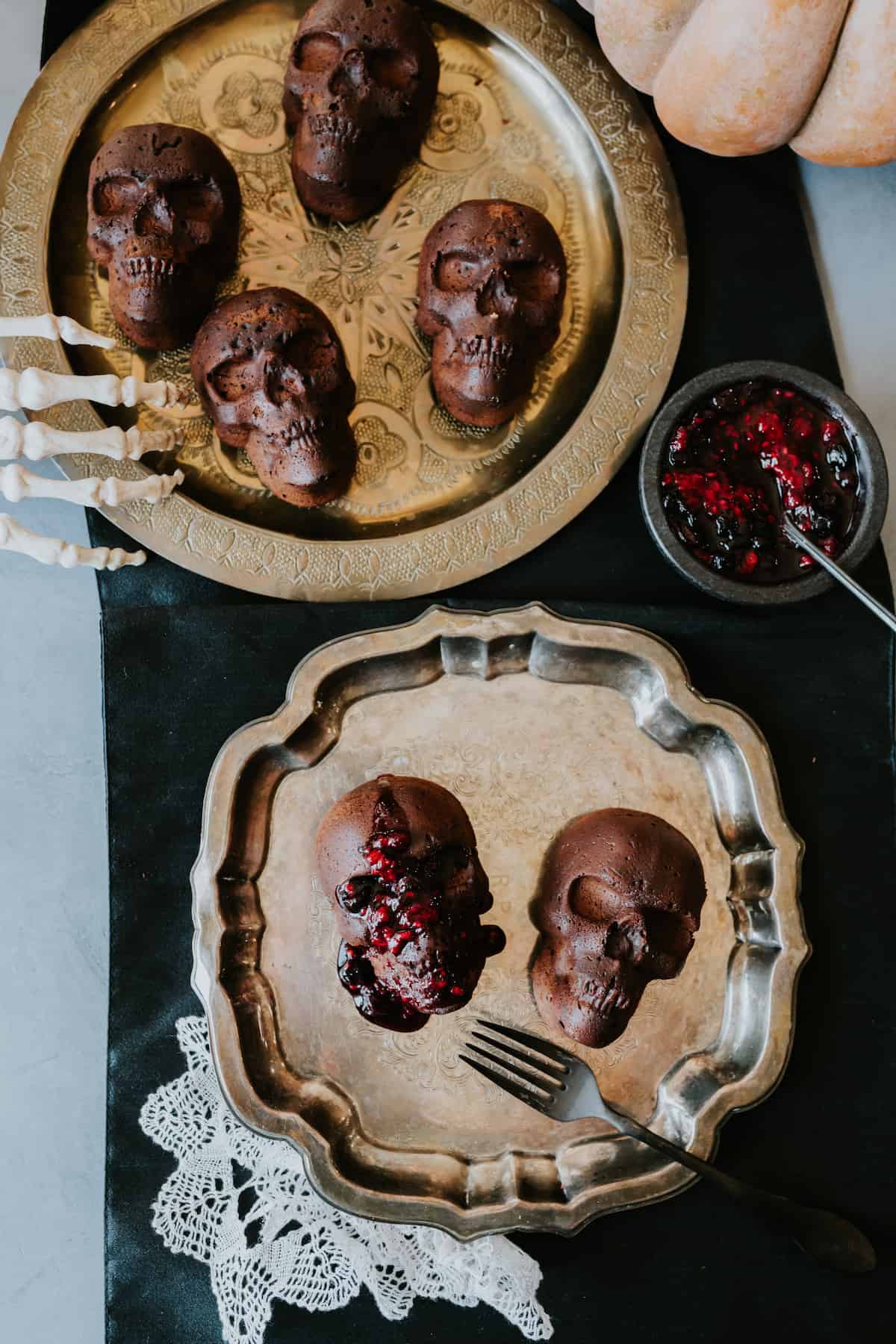Mexican Chocolate Skull Cakes in gold vintage plates with a skeleton hand on the side