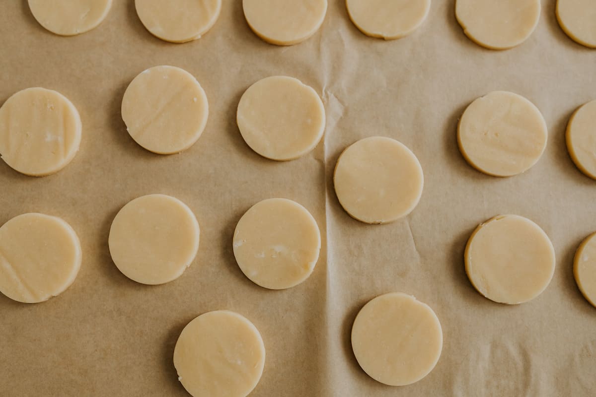 unbaked circles of lemon sugar cookie dough on a baking sheet lined with parchment