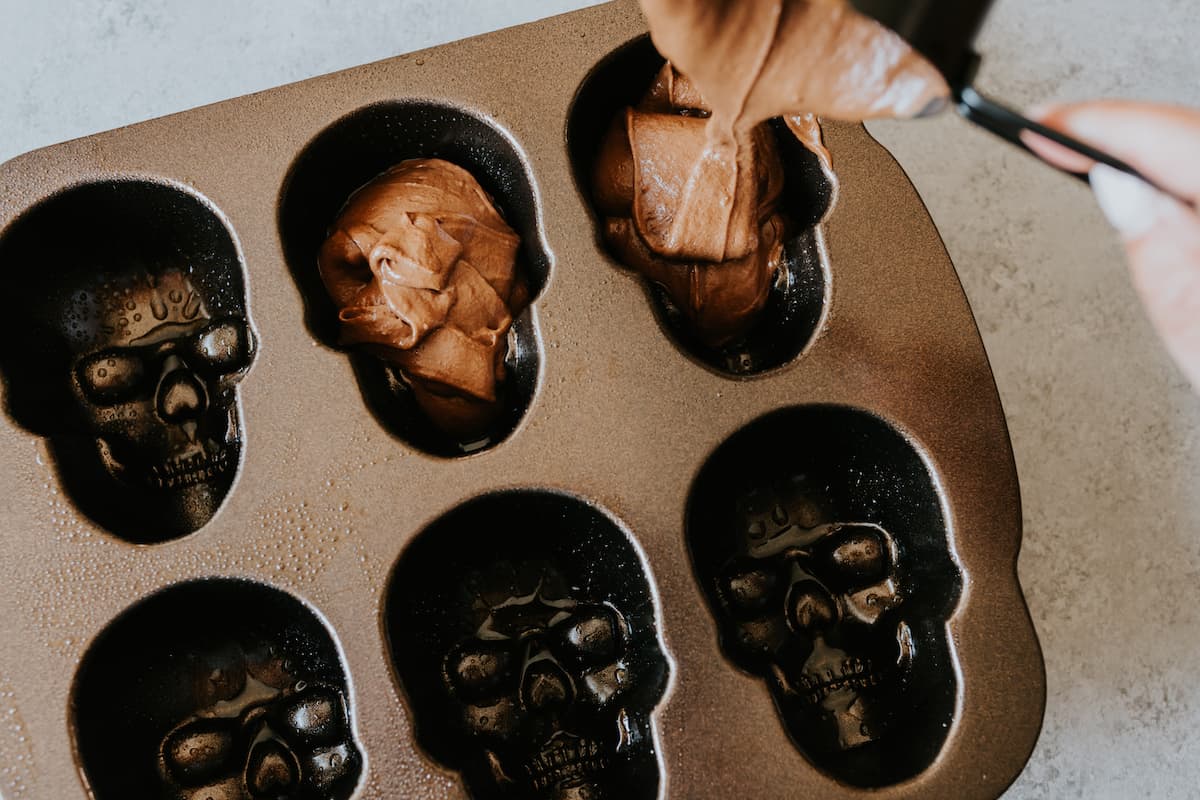 batter being poured into skull cake molds