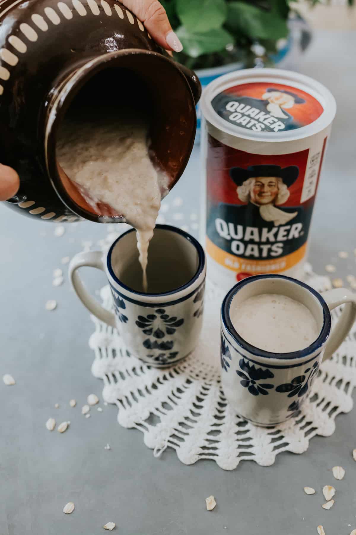 Atole de Avena being poured in cups with Quaker Oats in the background 