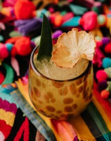 giraffe speckled glass filled with flor de piña cocktail.