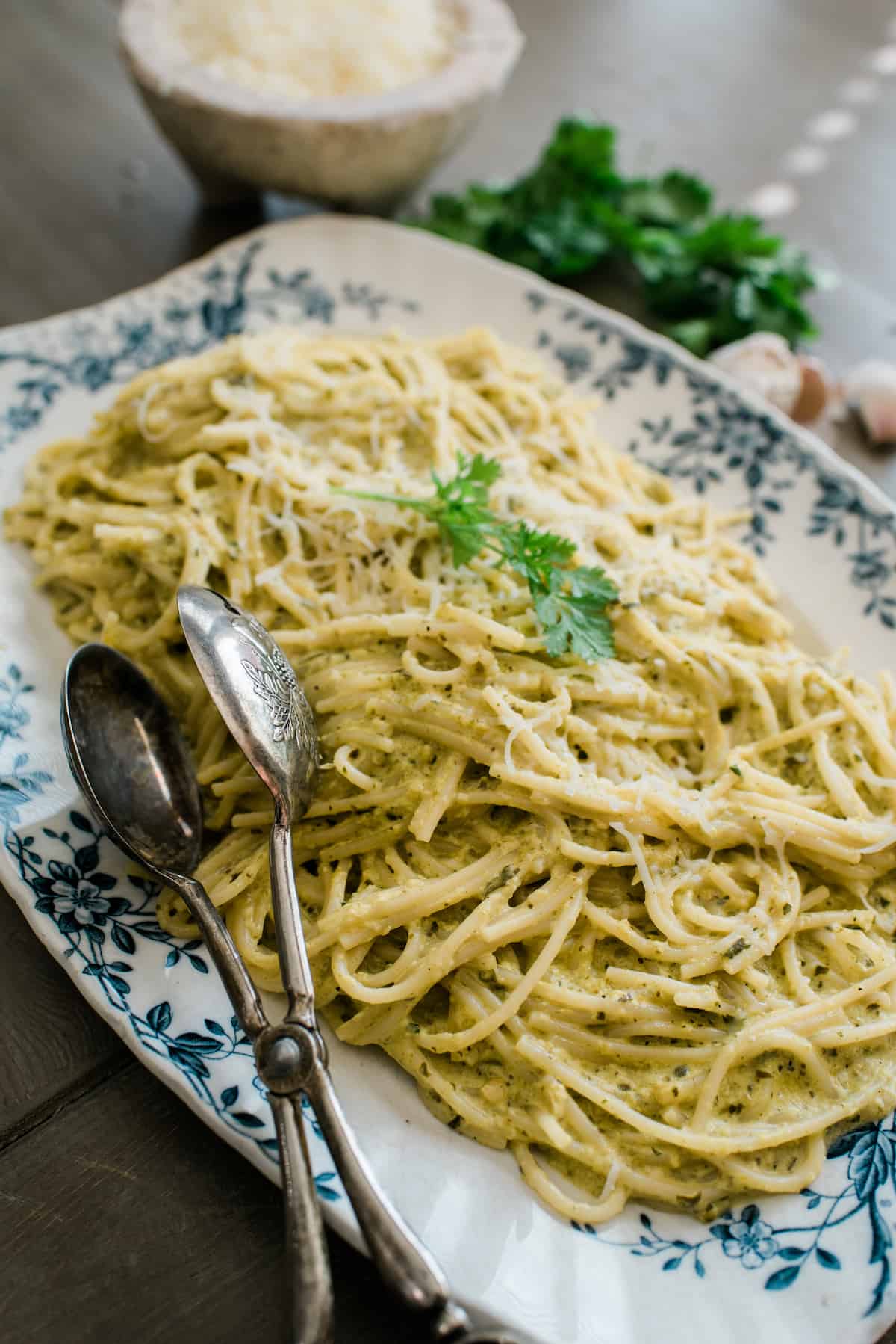 vintage platter filled with green spaghetti loaded with poblano cream sauce.