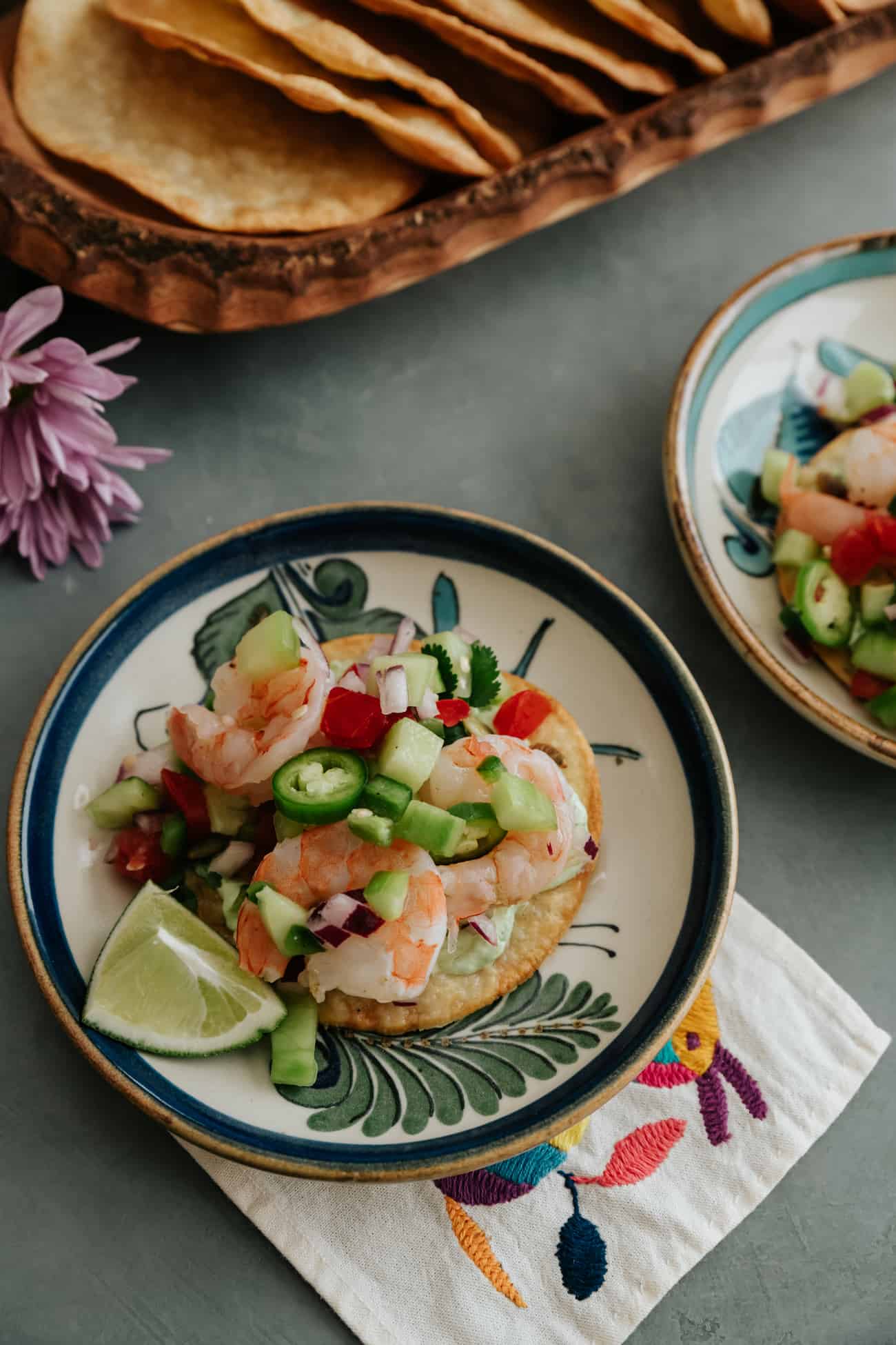 shrimp ceviche topped on tostada on a painted Mexican plate.