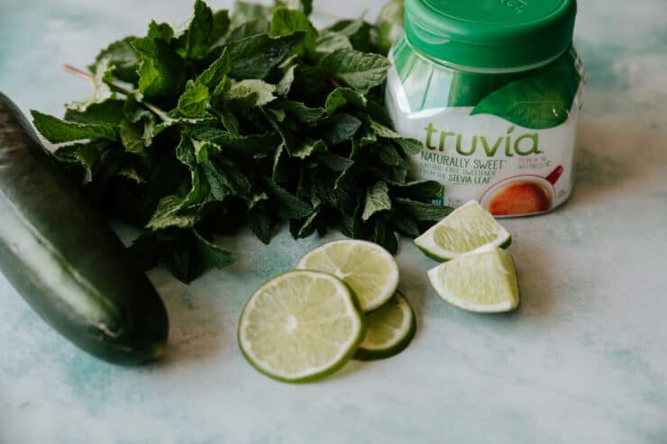cucumber, sliced lime, fresh mint, and a container of truvia sweetener. 