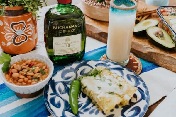 green enchiladas with a tall glass of whisky horchata.