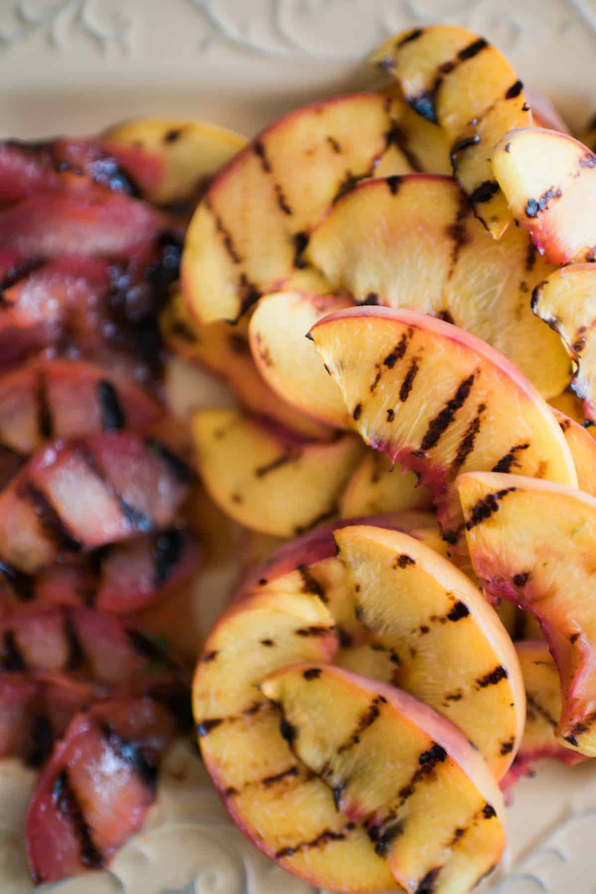 close up of grilled stone fruits like peaches and plums.
