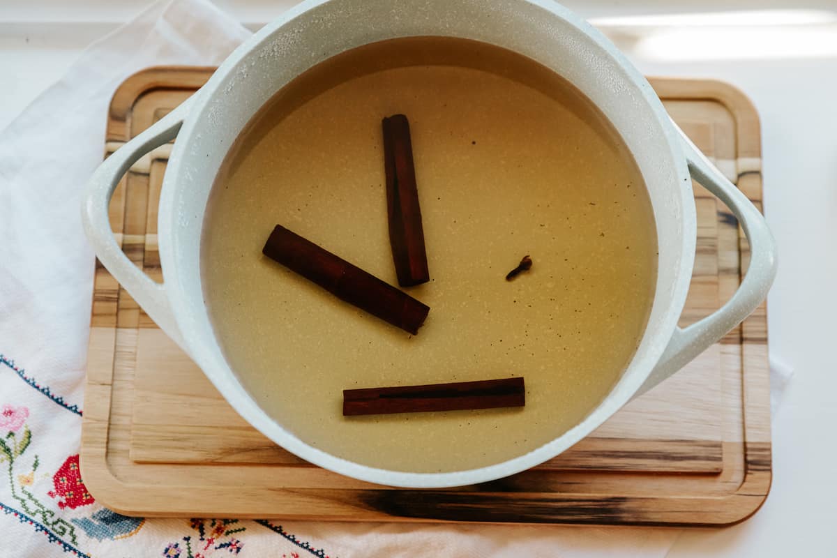 cinnamon sticks and clove steeping in hot water for making avena. 
