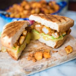 Breakfast Tortas with Potatoes and Chorizo cut open on a cutting board.