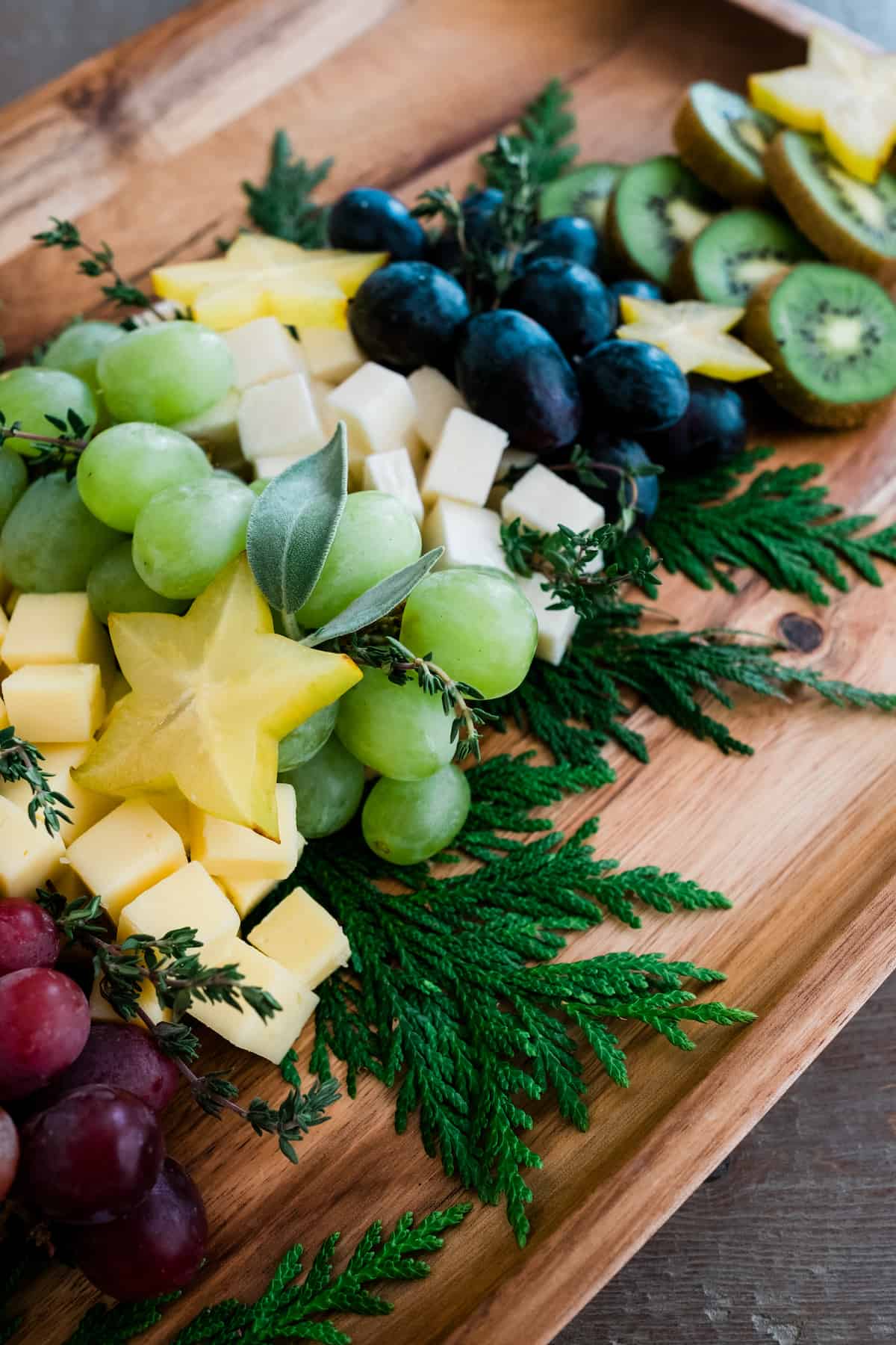 Christmas Tree Cheese Board closeup of star fruit sliced with grapes and kiwi.