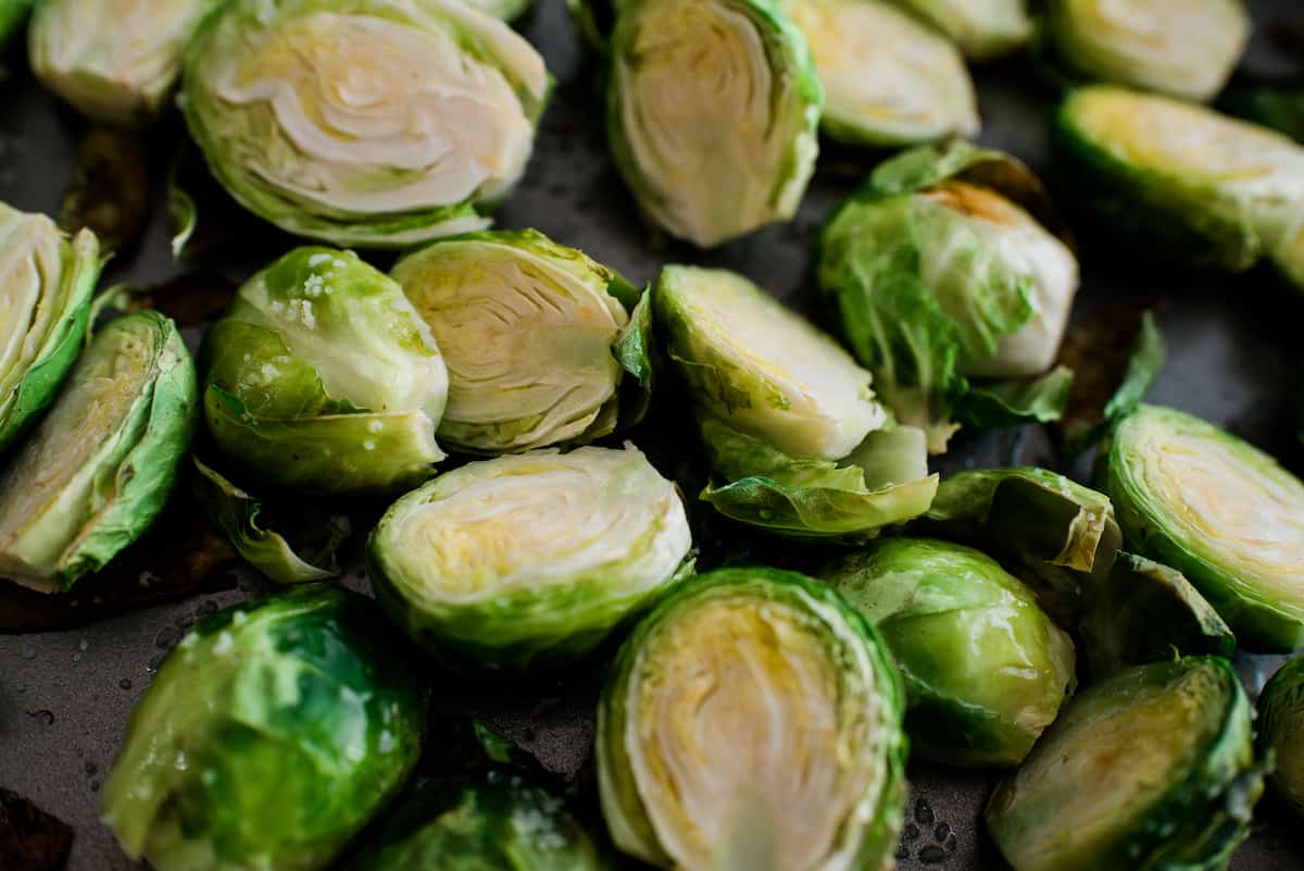 halved brussels sprouts on a sheet tray after tossing with oil and salt.