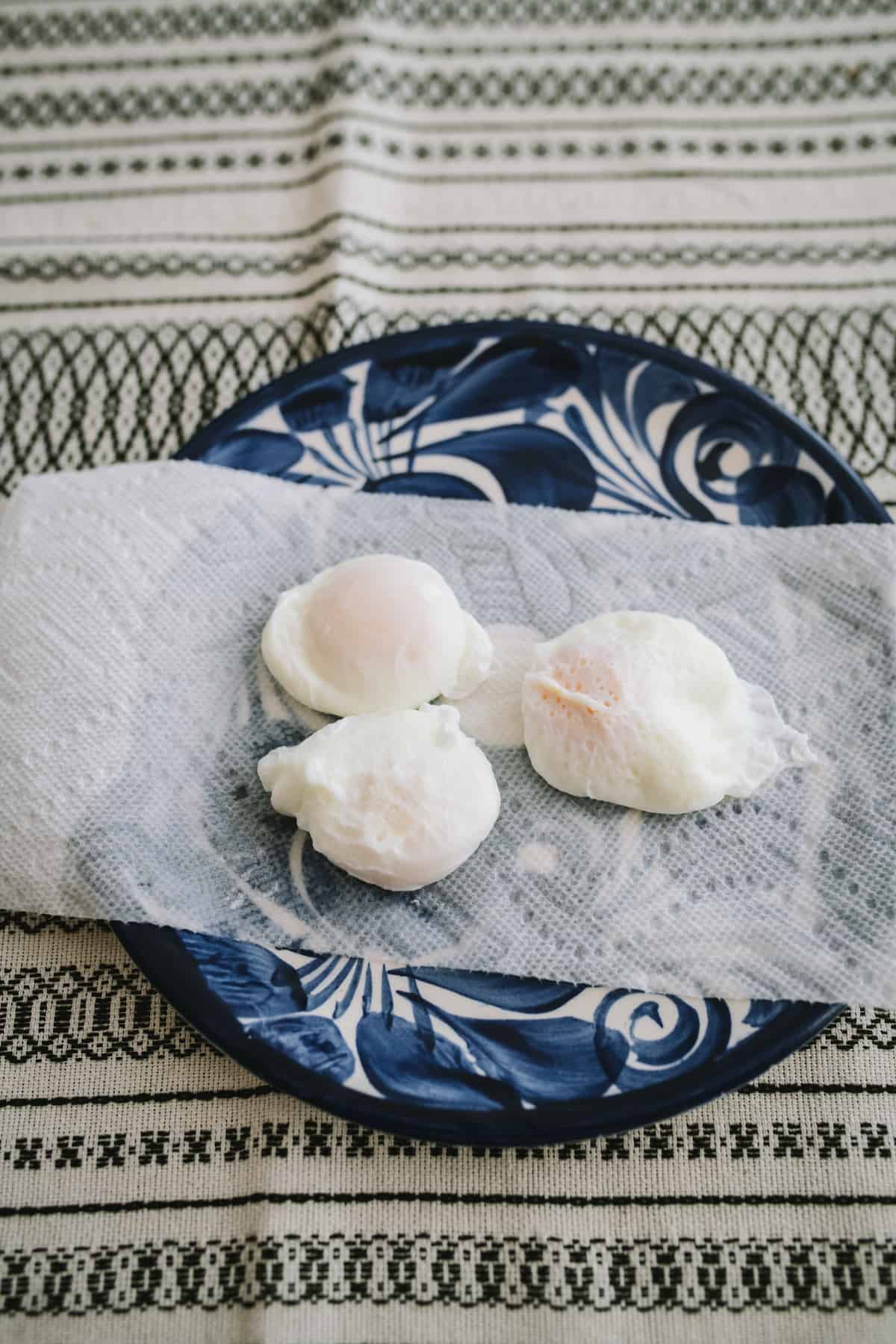 draining poached eggs on a paper towel.